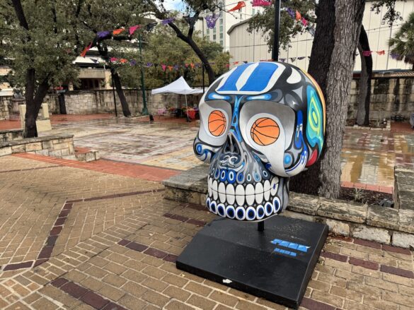 A smiling blue and black skull with basketball eyes.