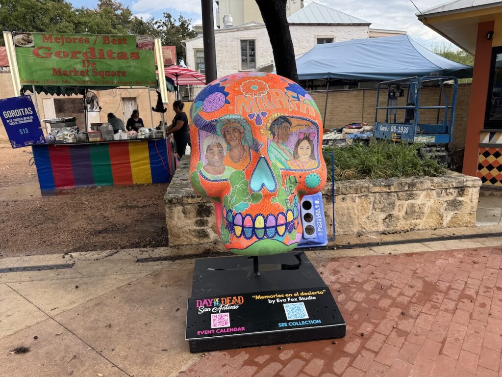 A skull with faces painted around the eyes and multi-colored teeth.